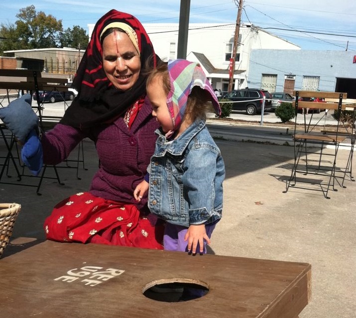 Sage rocks the head scarf as she learns bean bag toss at Refuge Coffee